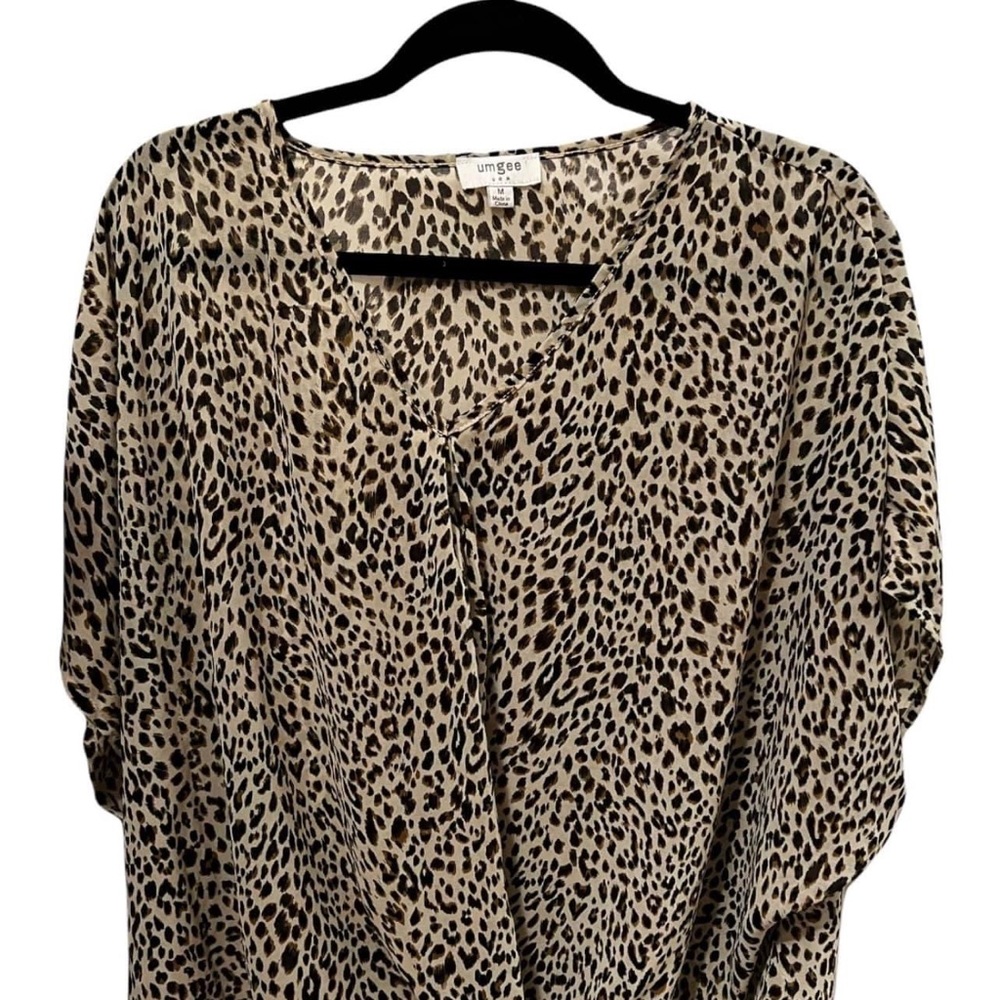 Andora Boutique- Thin Silk like shirt, with a twist near the bottom.